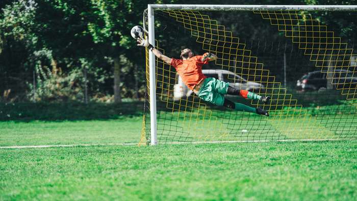 Keeper som forsøker å redde ballen fra å gå i mål