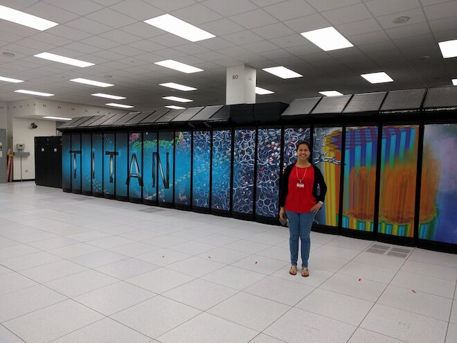Lupe standing in front of a supercomputer