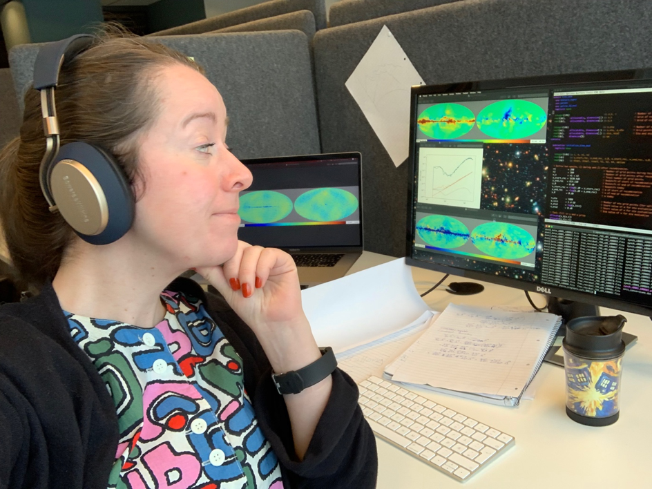 Ragnhild Aurlien staring at the PC screen with code lines and graphs.