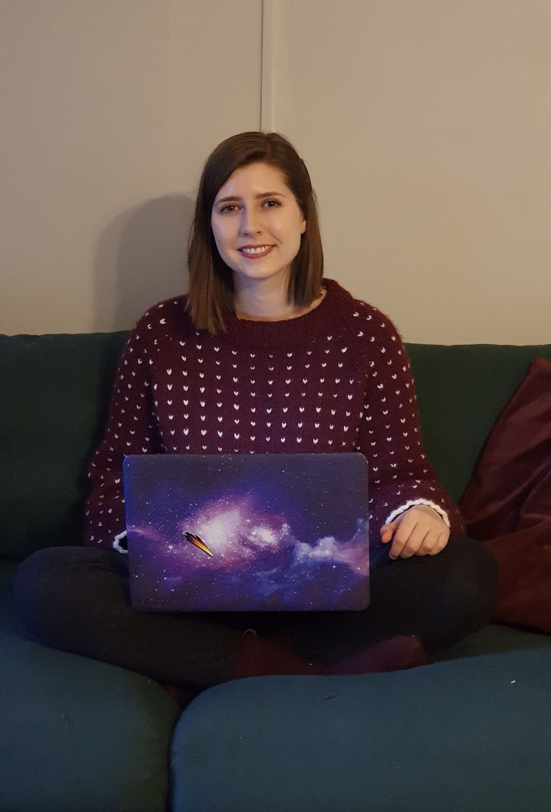 photo of Renate Mauland-Hus sitting on the couch with a Milky Way decal cover laptop 