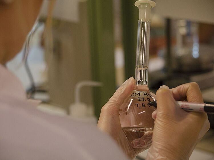 Person som skriver på en laboratoriekolbe