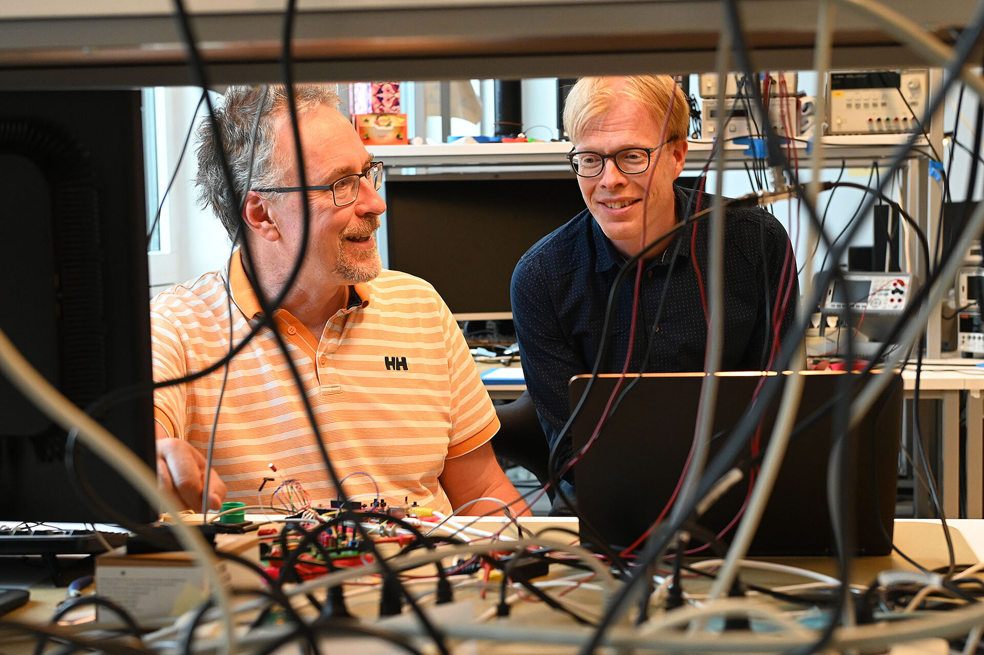to personer på lab, ledninger, elektronikk-komponenter, oscilloskop