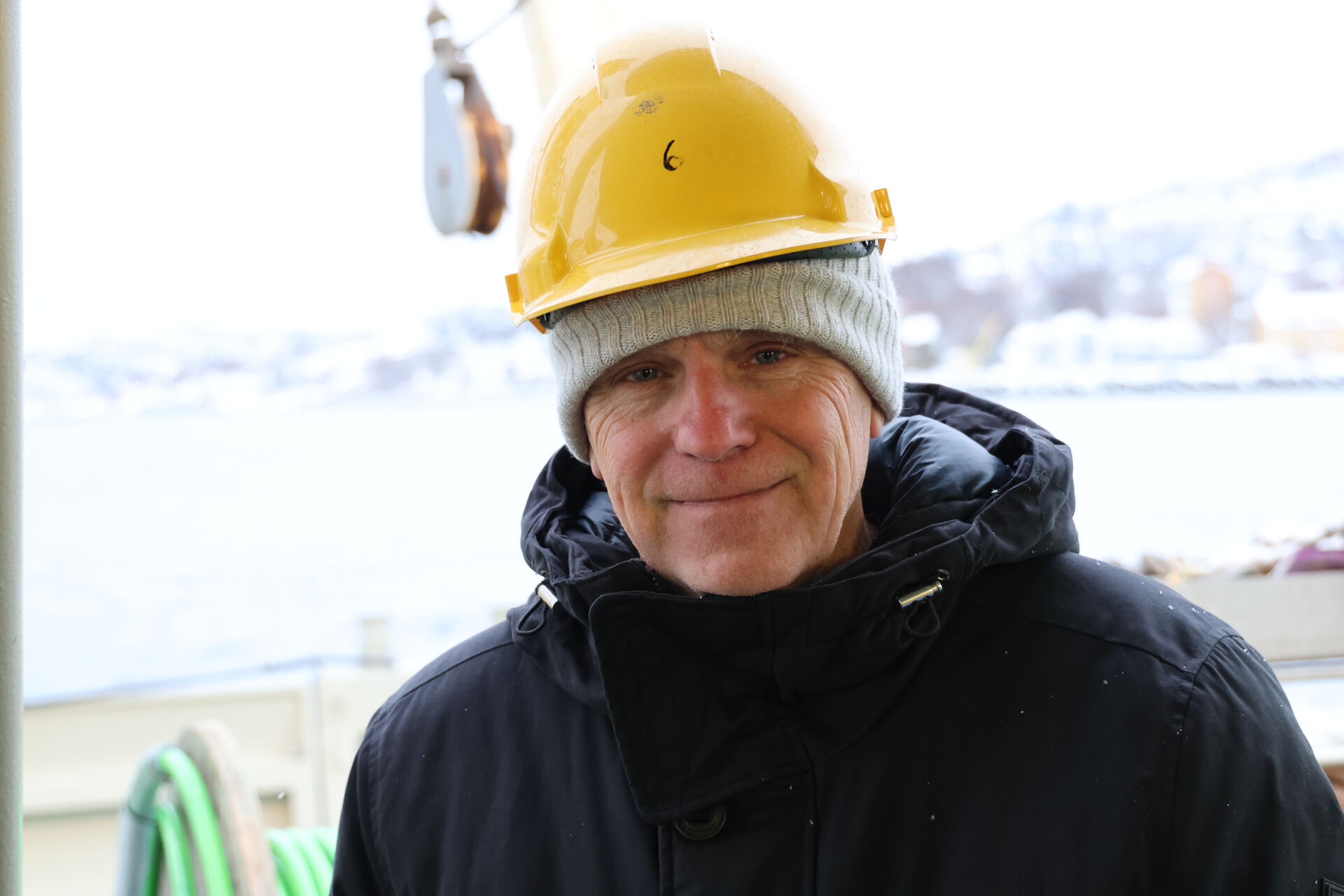 Bildet kan inneholde: hjelm, ansikt, smil, hjelmhatt, arbeidstøy.