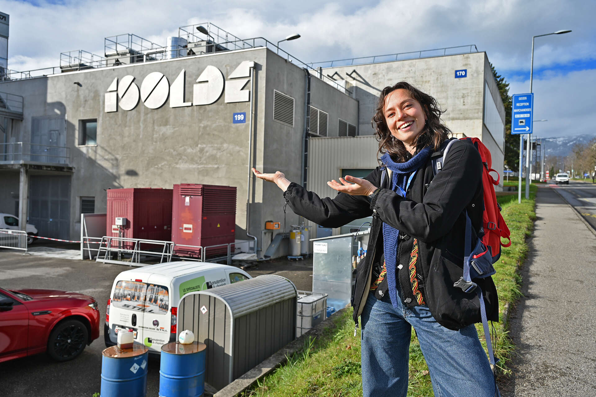 person utenfor betong-bygning med Isolde-skilt